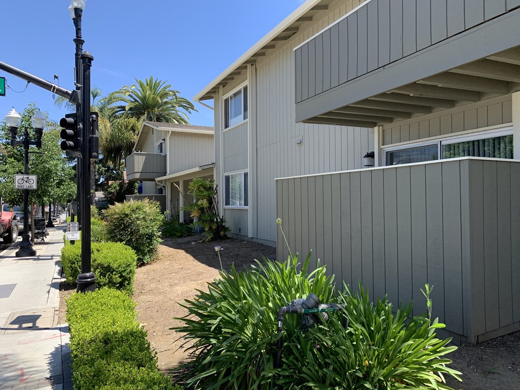 a sidewalk in front of a building with a traffic light