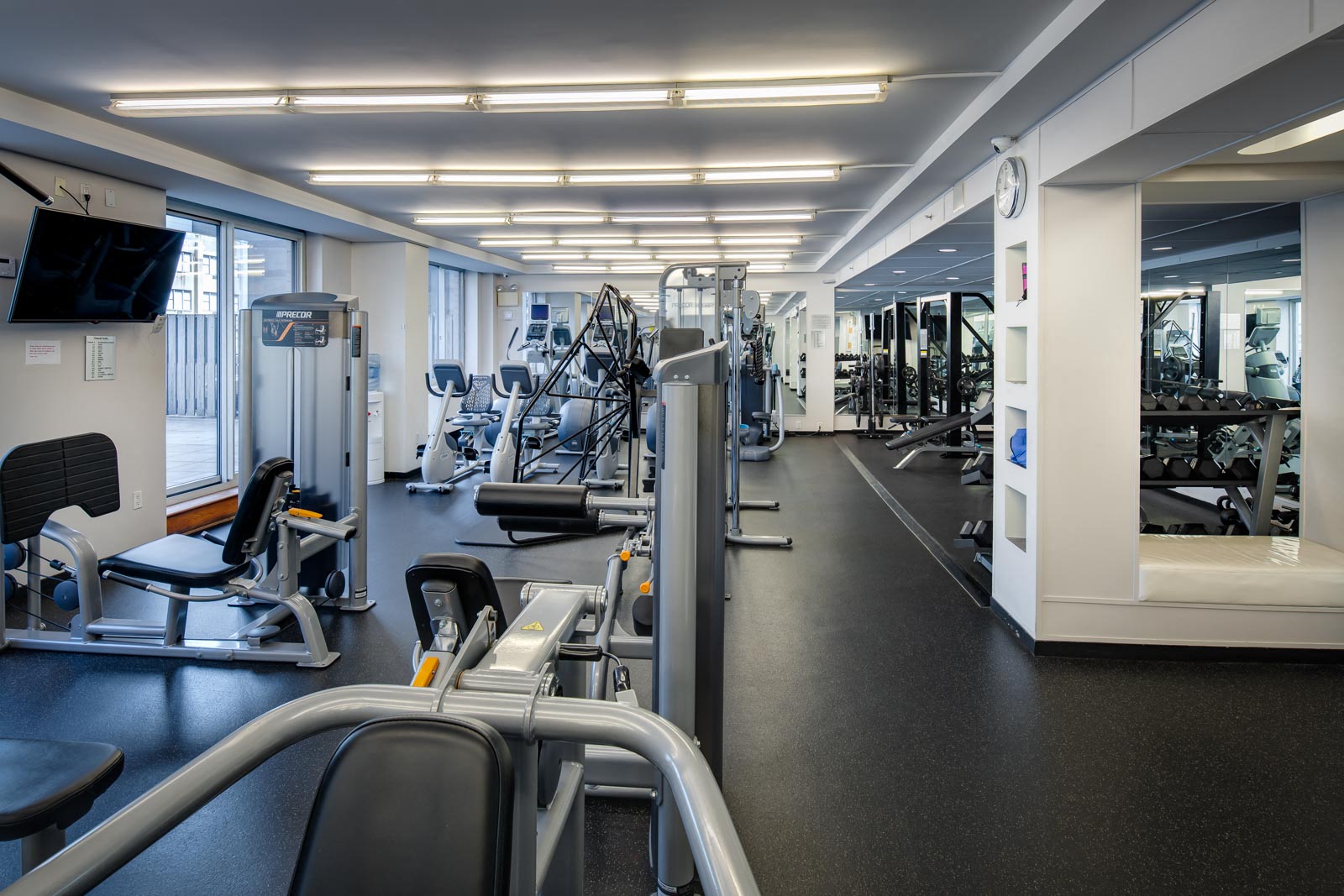 a gym with cardio equipment and weights in a building