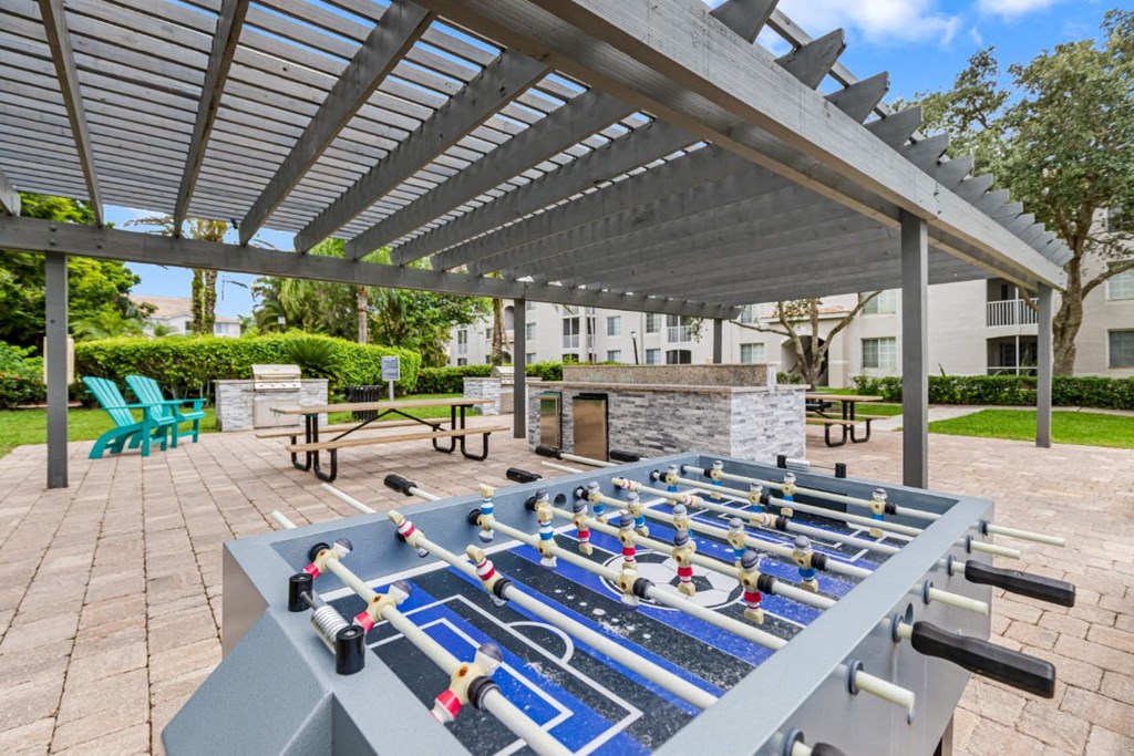 an outdoor gym with weights on a table under a large shade