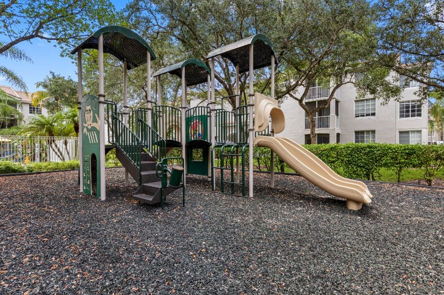 a playground with a slide in front of an apartment building