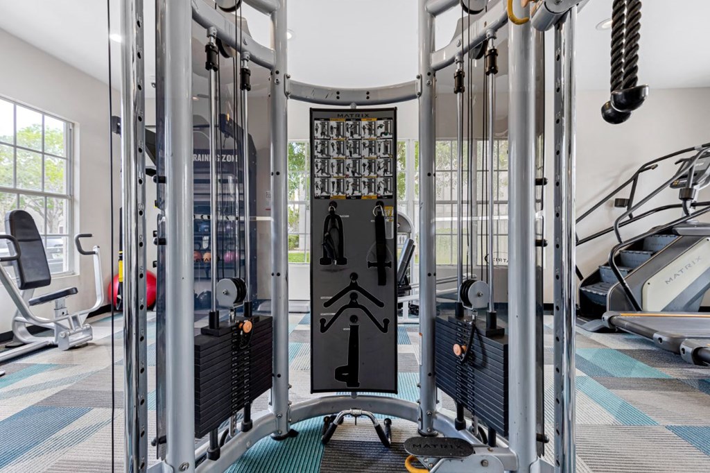 a gym with weights machines and a glass door in the middle