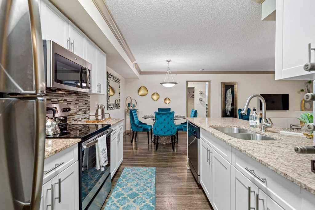 a kitchen with white cabinets and granite counter tops