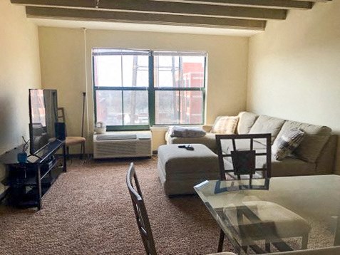 a living room with a couch and a table and a window