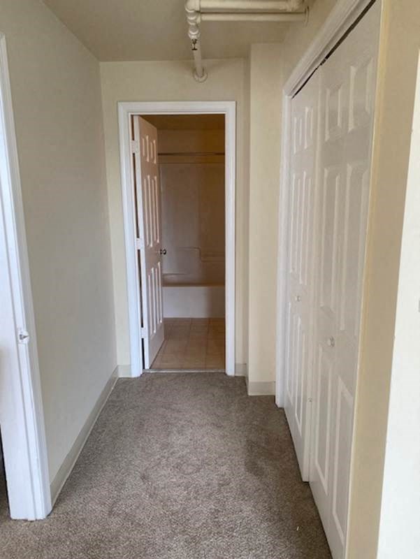 a hallway with a closet and a door to a bathroom