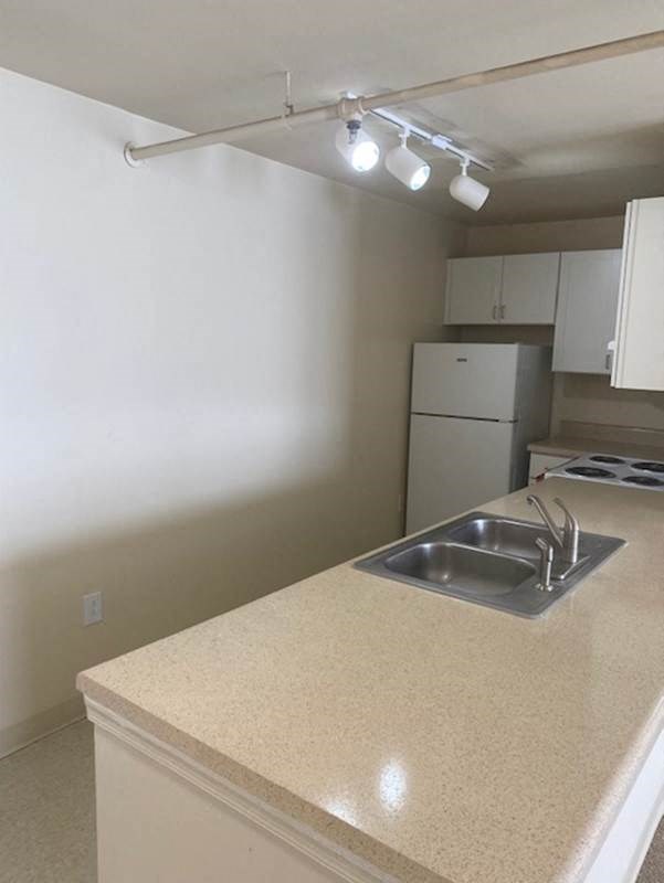 an empty kitchen with a sink and a stove