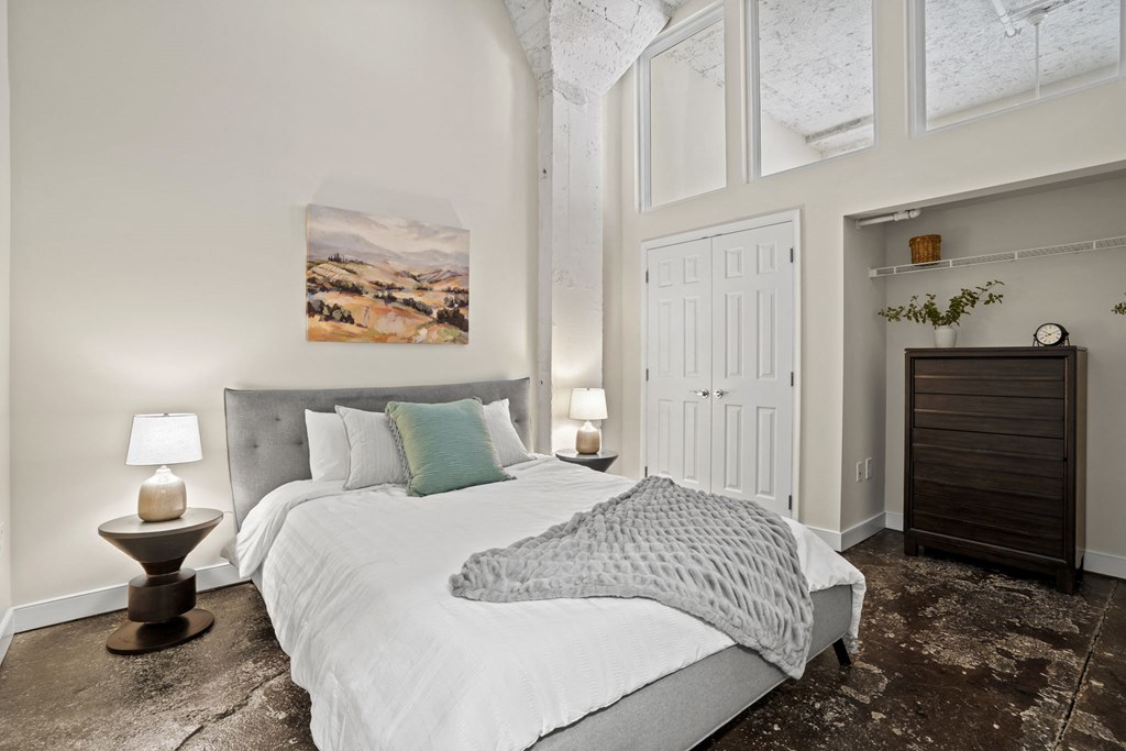 a bedroom with a bed and a large window