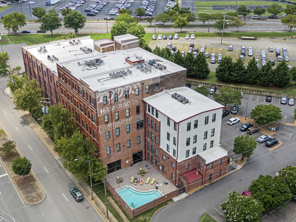 an aerial view of a building with a pool and a parking lot