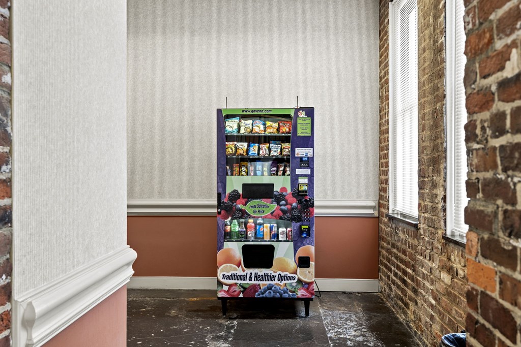 a vending machine in a room next to a brick wall
