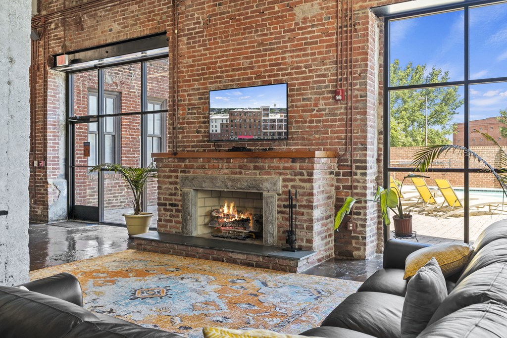 the living room has a brick fireplace and a tv above it
