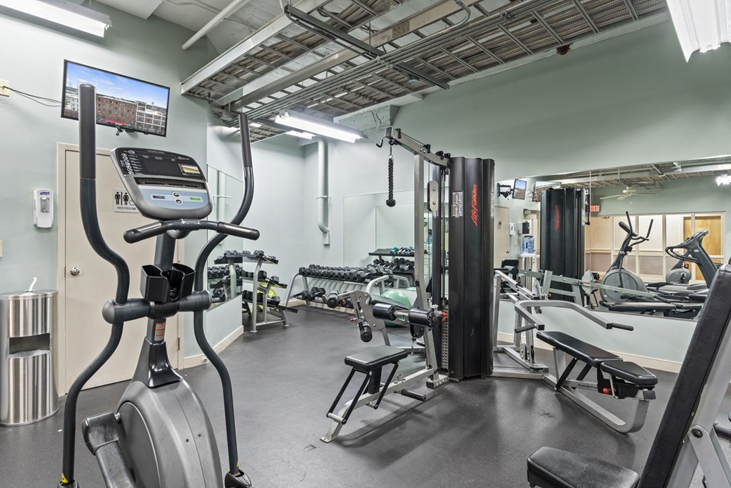 a gym with cardio equipment and weights in a building