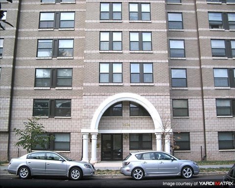 Two cars parked in front of a building with the number 2544 on it.
