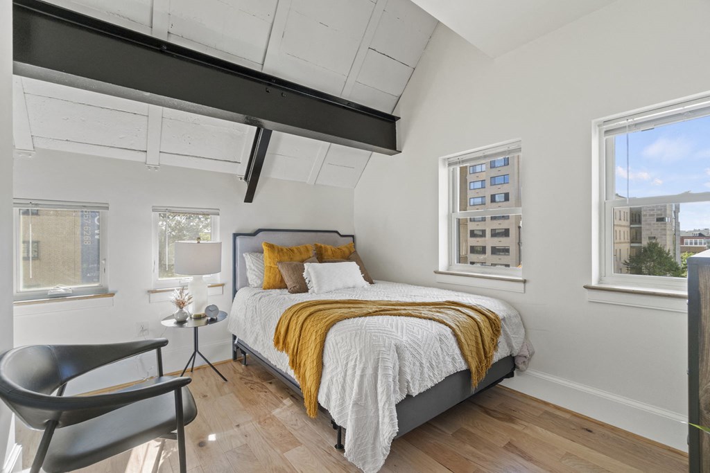 a bedroom with a bed and two windows