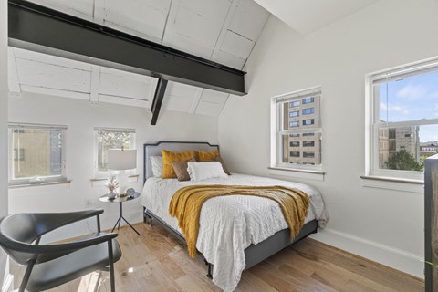 a bedroom with a bed and two windows