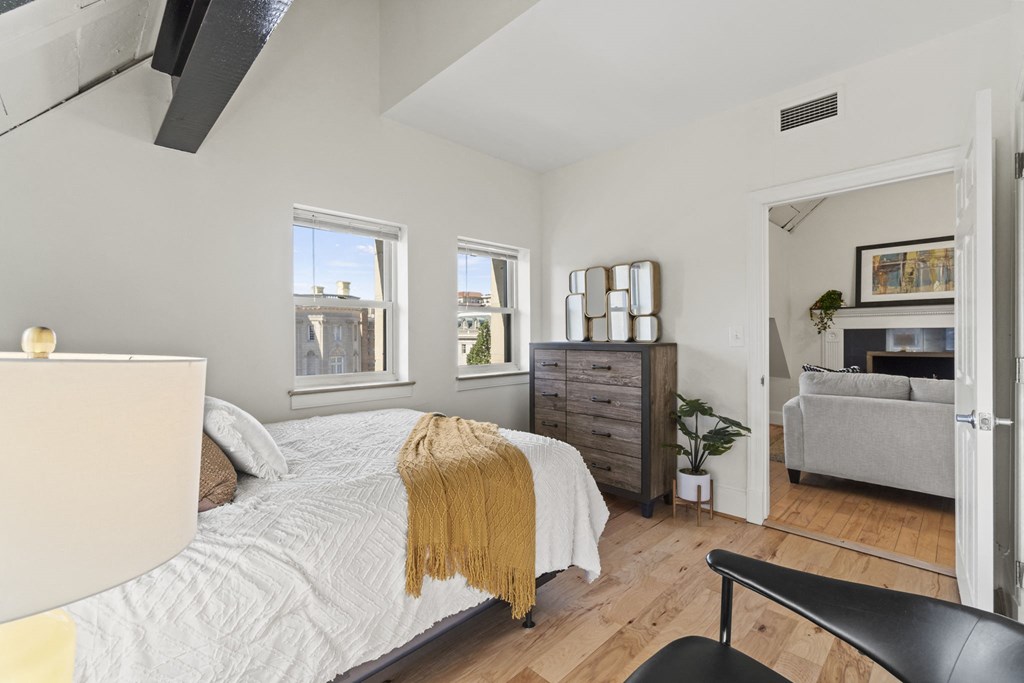 a bedroom with a bed and three windows