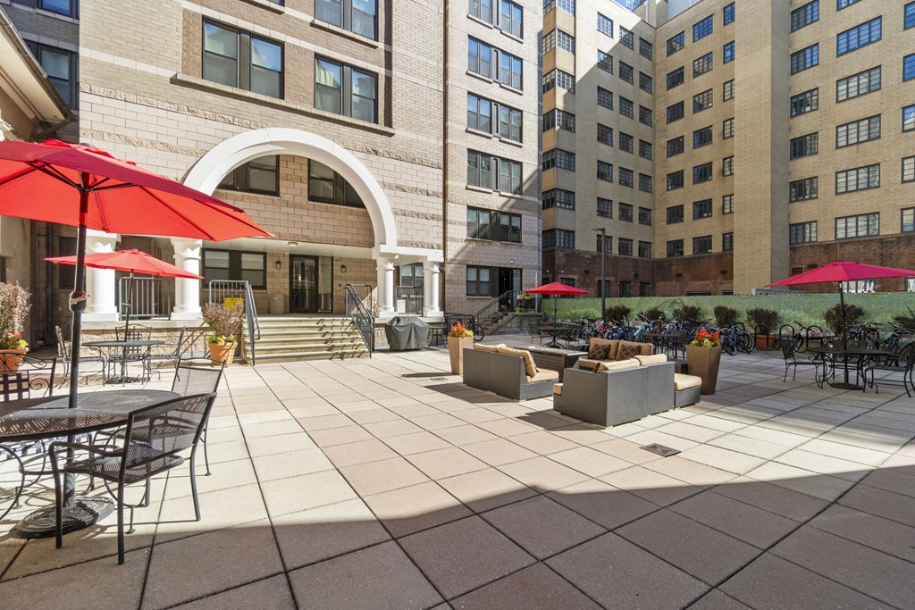 a patio with tables and chairs and umbrellas in front of a building