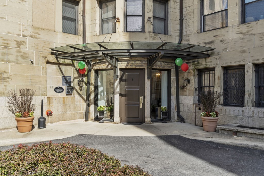 the front entrance of a building with a brown door