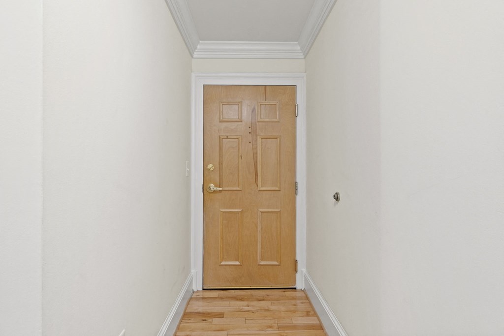 a door in a room with a wooden floor and white walls