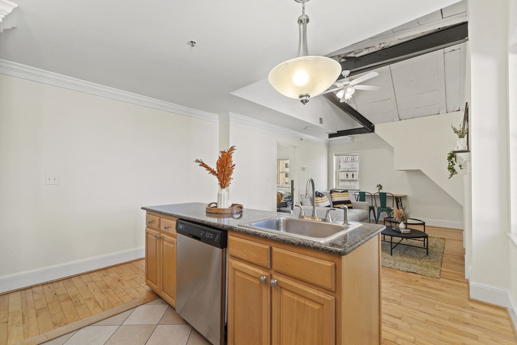 a kitchen with wooden cabinets and a stainless steel dishwasher