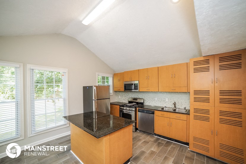 a kitchen with wooden cabinets and stainless steel appliances