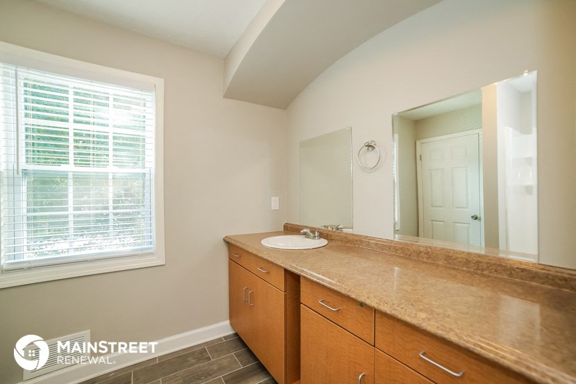 a bathroom with a sink and a mirror and a window