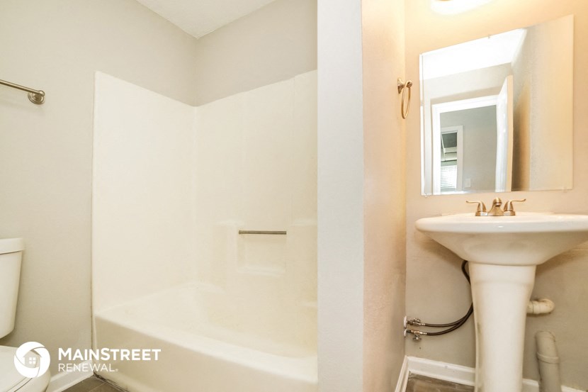 a bathroom with a sink and a shower and a mirror