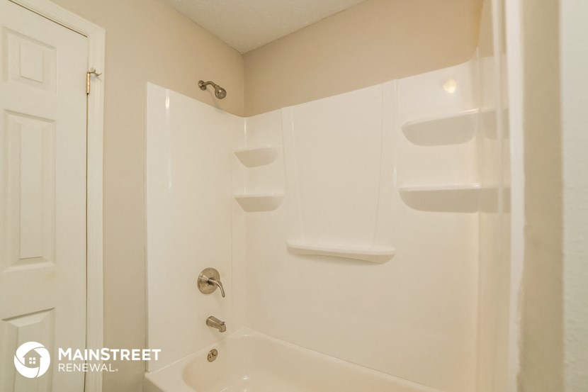 a white bathroom with a shower and a sink