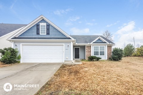 a white and blue house with a driveway and a garage door