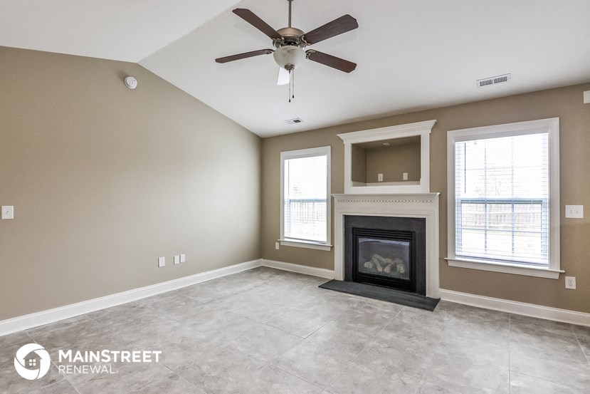 the living room with fireplace and ceiling fan