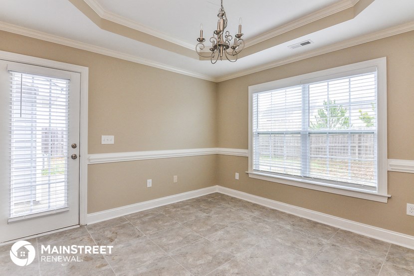 a dining room with a chandelier and two windows