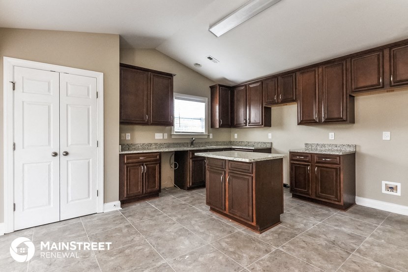 a kitchen with dark wood cabinets and a white door