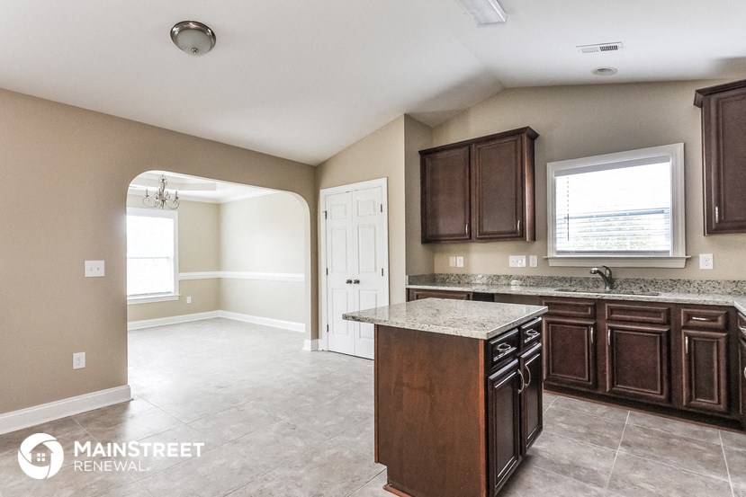 a kitchen with brown cabinets and a marble counter top