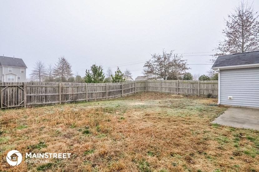 the backyard of a house with a wooden fence