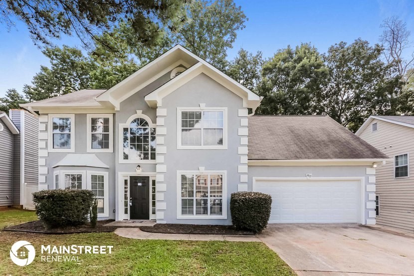 the exterior of a white house with a garage and a lawn
