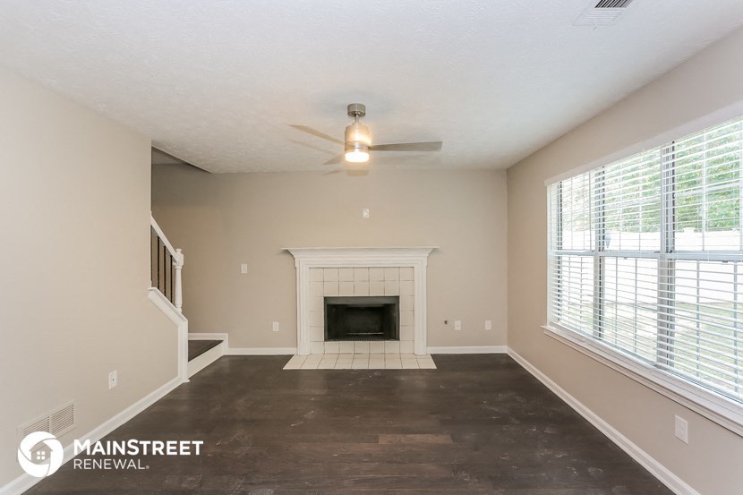 the living room has a fireplace and large windows