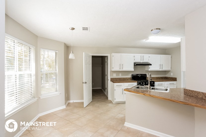 a kitchen with white cabinets and a counter top