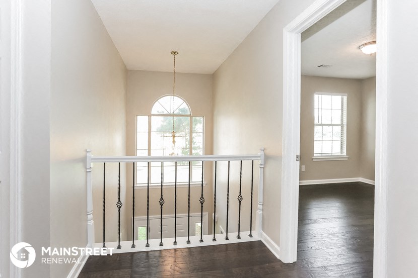 an empty living room with a balcony and a window