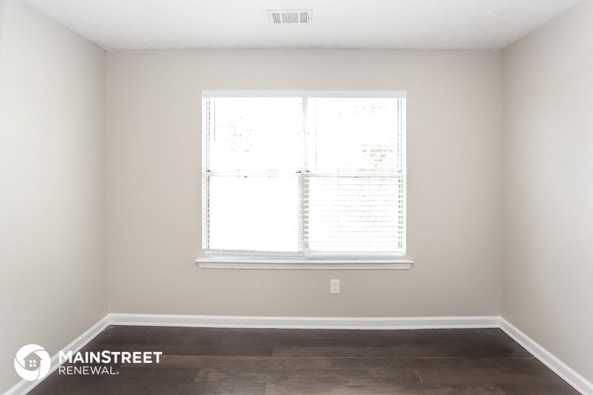 a living room with a window and a wooden floor