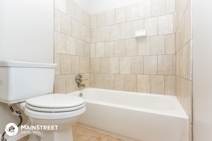 a bathroom with a toilet and a bath tub