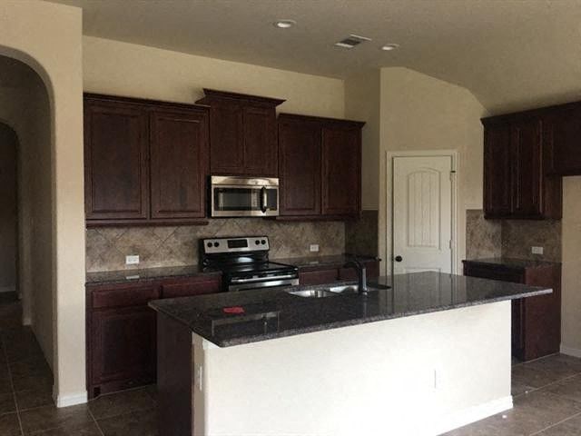 a kitchen with a counter top and a stove