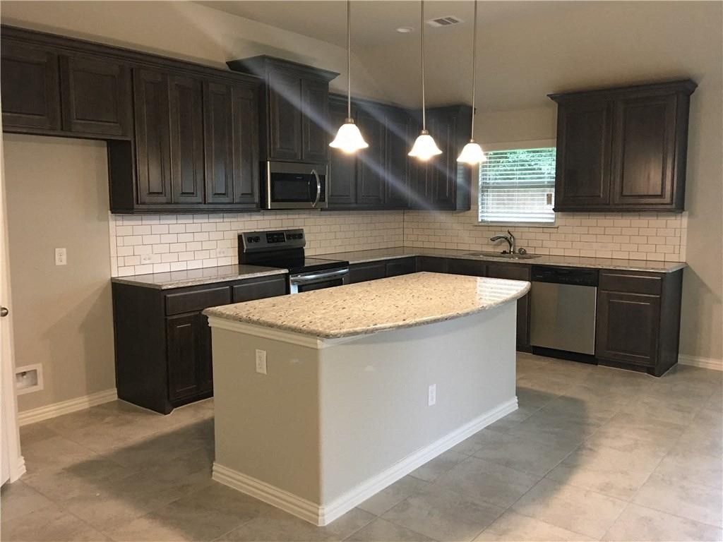 an empty kitchen with a counter top in the middle