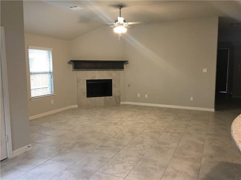 a living room with a fireplace and a ceiling fan