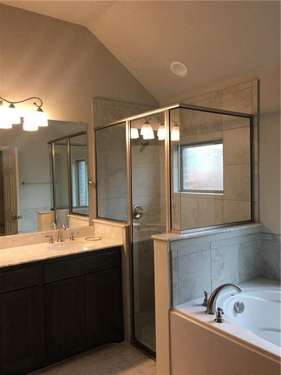 a bathroom with a tub and a shower and a sink