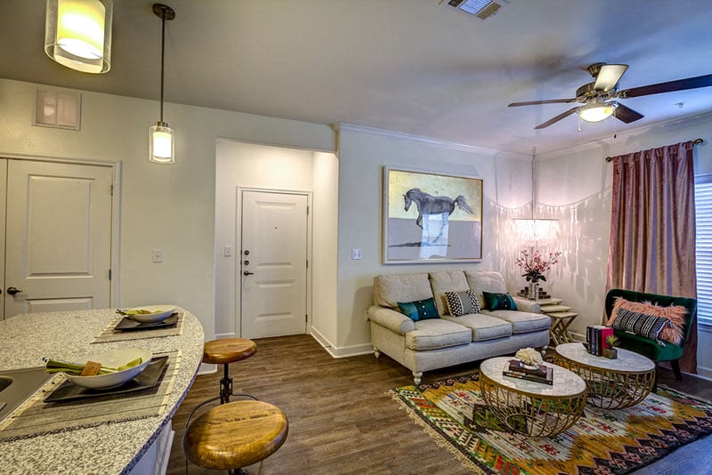 A living room with a couch, a chair, and a painting on the wall.