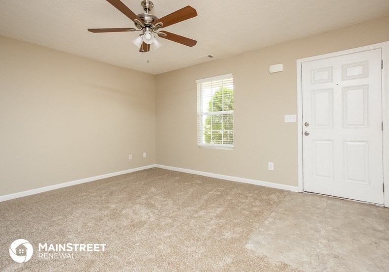 an empty room with a ceiling fan and a door