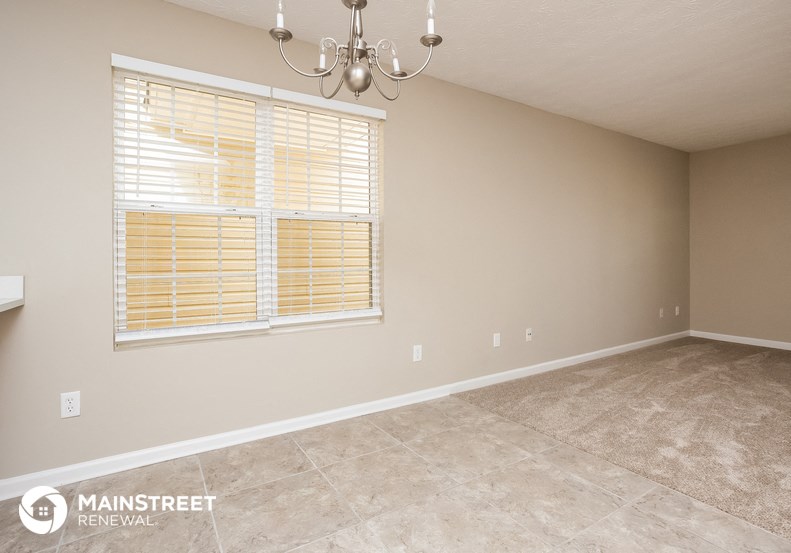 a living room with a chandelier and a large window