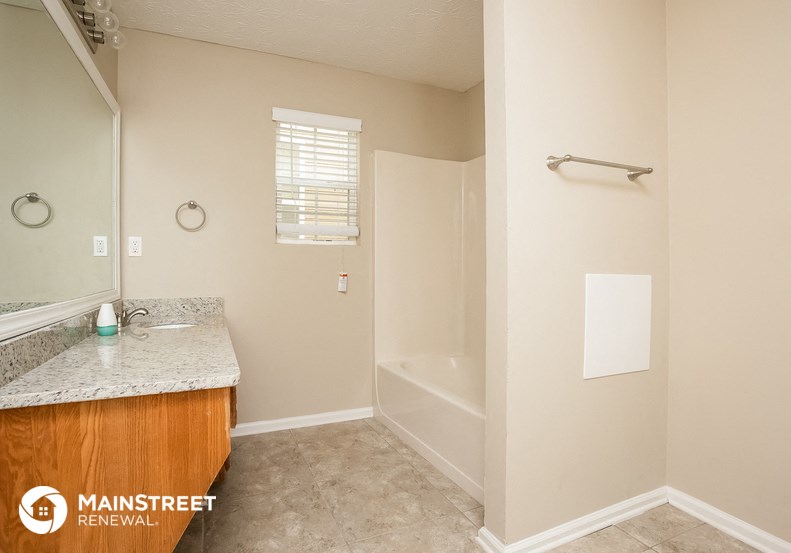 a bathroom with a shower and a sink and a mirror