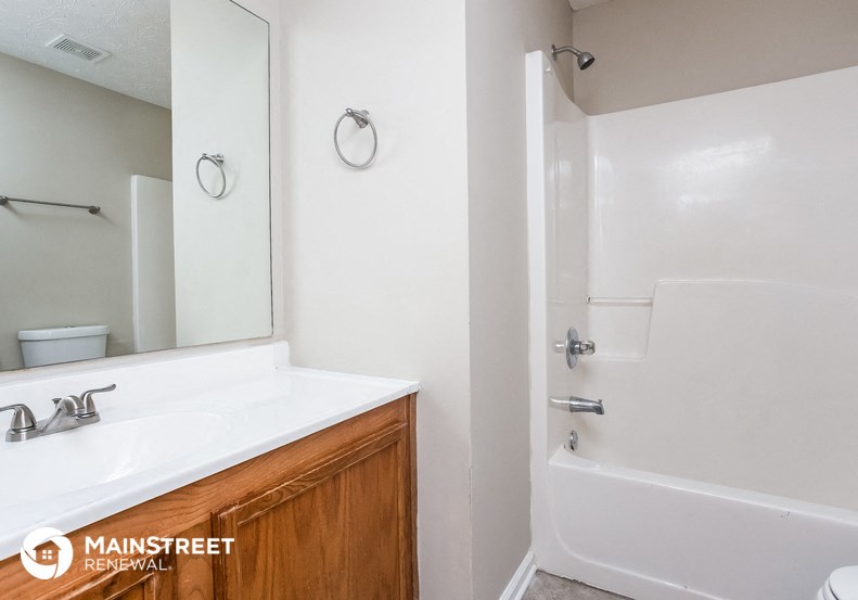 a bathroom with a sink and a shower and a mirror