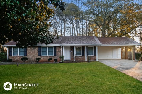 a brick house with a lawn and trees
