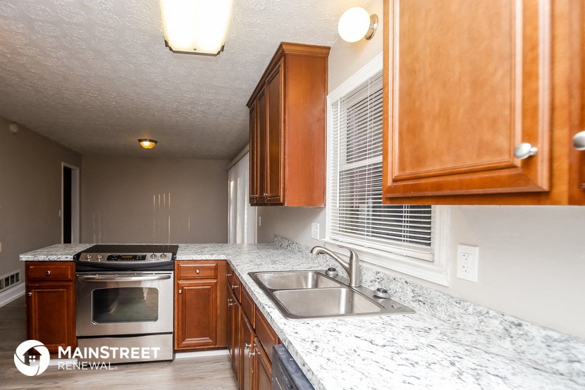 a kitchen with marble counter tops and wooden cabinets
