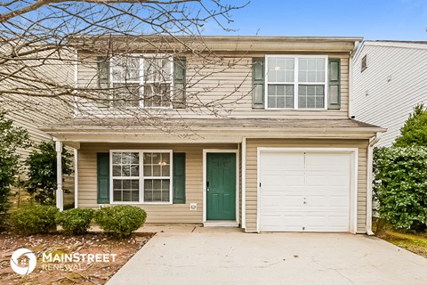 a house with a green door and a white garage door